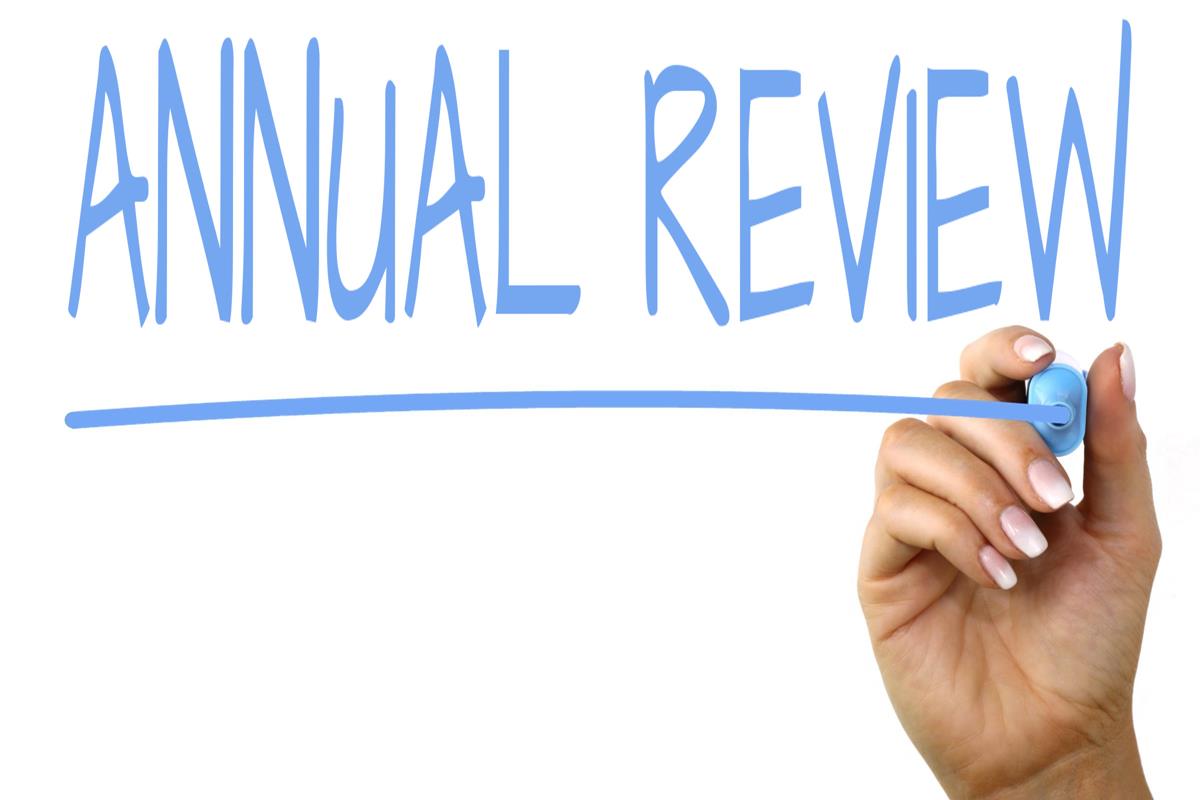 A hand writes 'Annual review' in blue pen