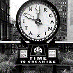 Black and white image of a clock. Instead of numbers there are random letters.