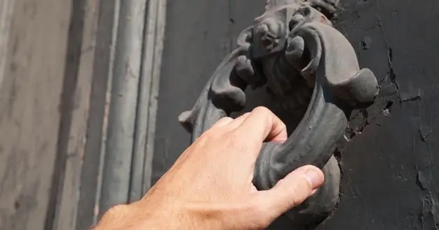 A hand on a door knocker