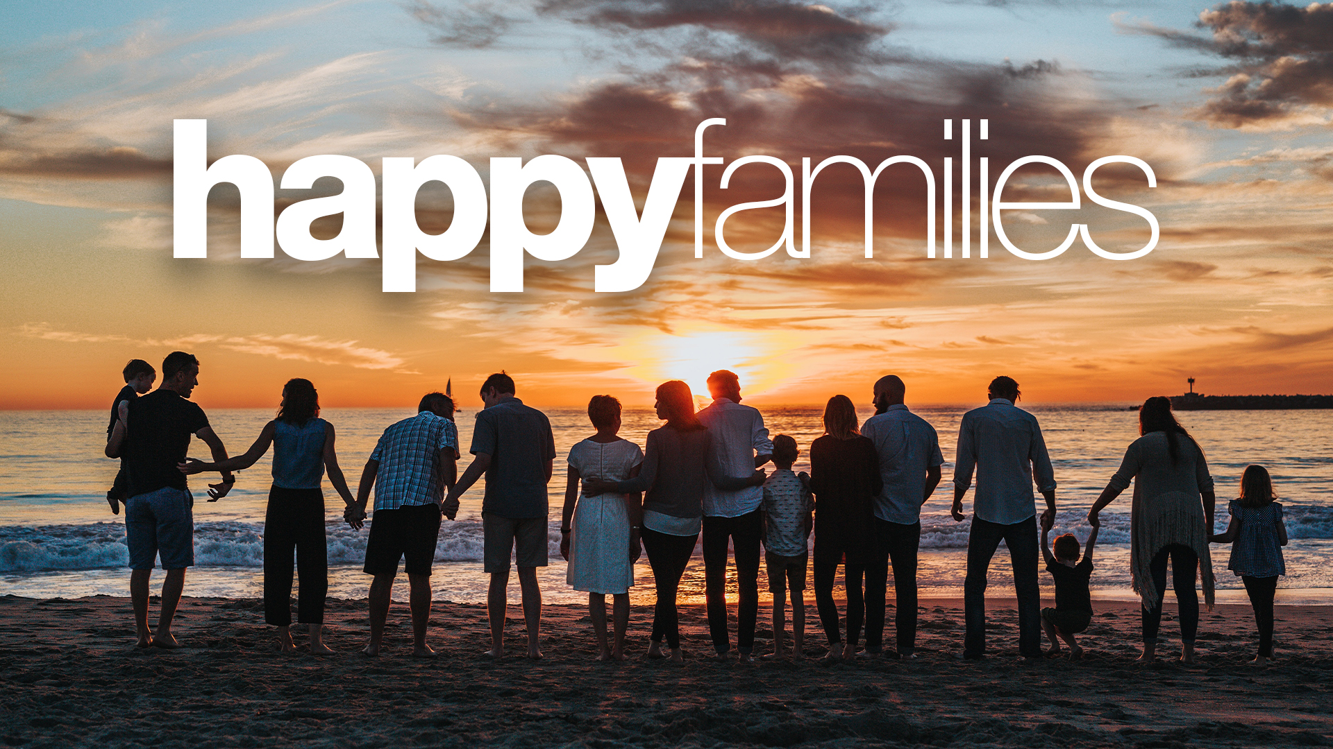 A large family stood on a beach watching the sunset