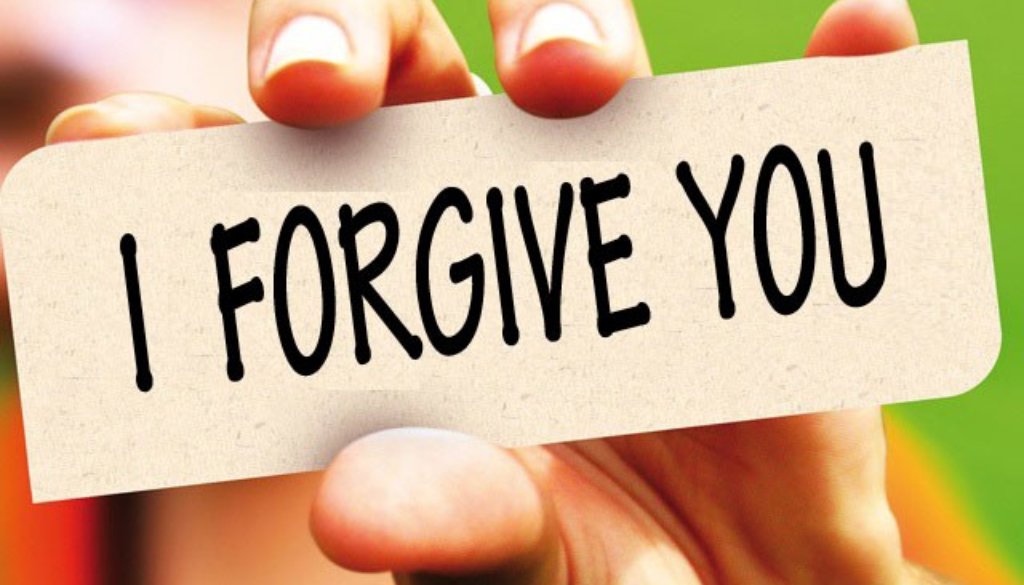 A hand is holding a card with 'I forgive you' on it