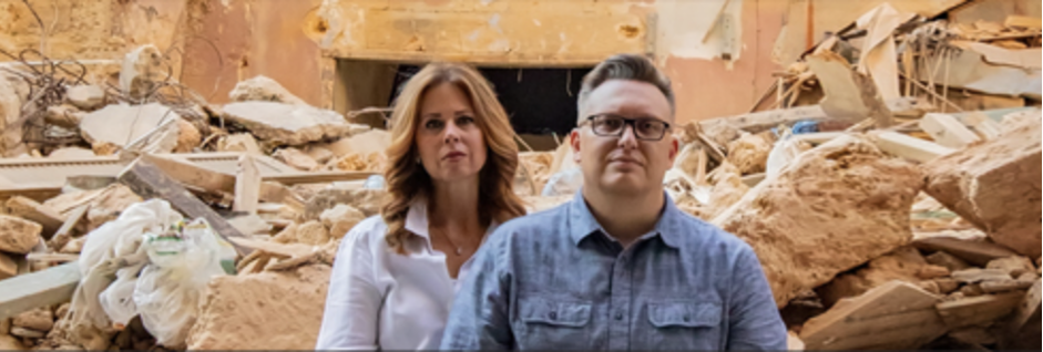 A photograph of Matt and Julie Beemer with rubble of a building in the background