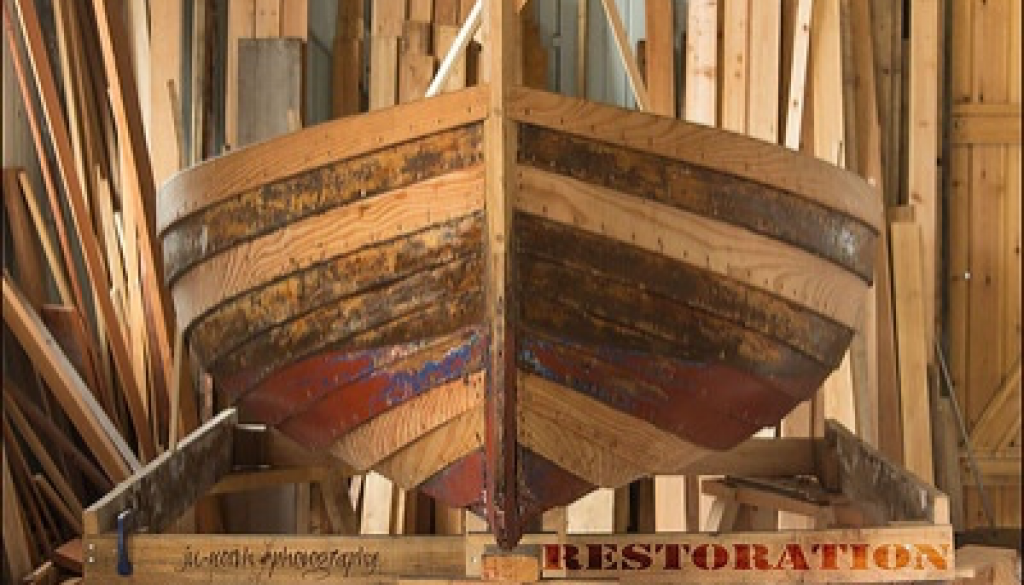 A wooden boat in a wordshop. Text reads 'restoration'