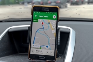 A satnav map on a mobile phone on a car dashbaord