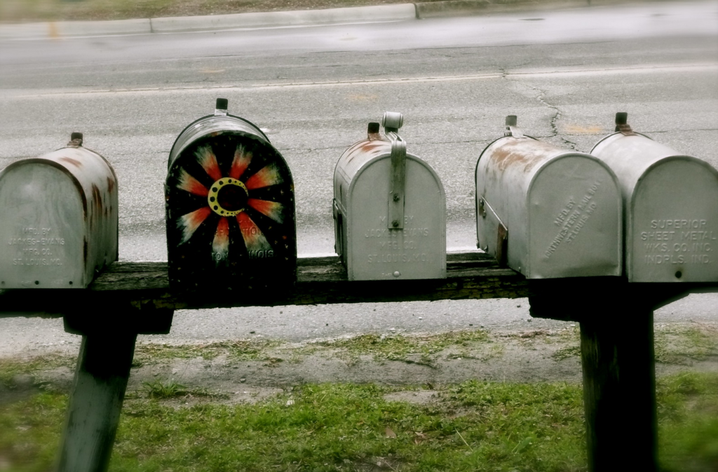 A line of US style home mailboxes, one is painted